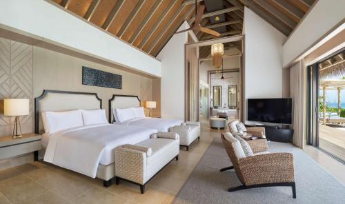 a bedroom with a large bed and a tv at Waldorf Astoria Maldives Ithaafushi in South Male Atoll