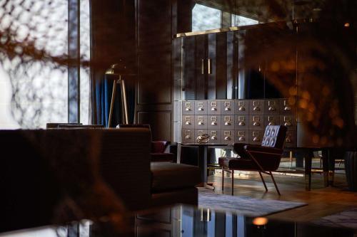 ドバイにあるWaldorf Astoria Dubai International Financial Centreのリビングルーム(テーブル、椅子、窓付)