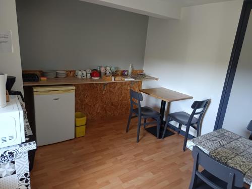 a kitchen with a table and chairs in a room at L'Albatros in Perros-Guirec