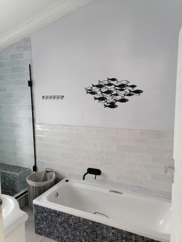 a bath tub in a bathroom with a toilet at Pearly Beach Cottage in Pearly Beach