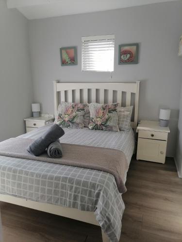 a bedroom with a bed with two night stands and a window at Pearly Beach Cottage in Pearly Beach