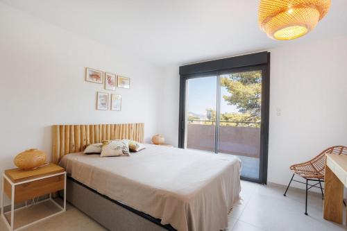 une chambre avec un lit et une grande fenêtre dans l'établissement vue mer époustouflante plage village à pied, à Hyères