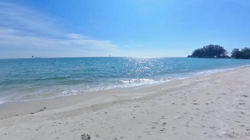 a beach with footprints in the sand and the ocean at 5-10 pax, GFloor cozy staycation chill place in Port Dickson