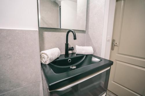 La salle de bains est pourvue d'un lavabo vert et d'une porte. dans l'établissement Face à la cité, Terrasse Et Climatisation - AE, à Carcassonne