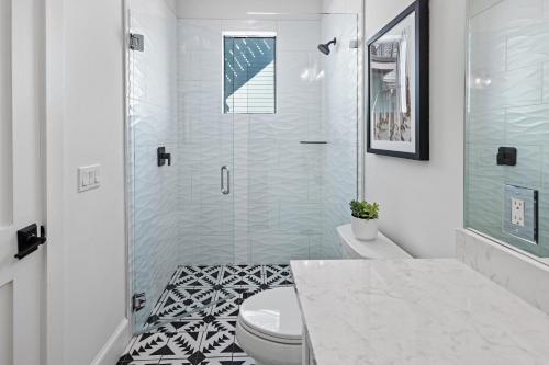 a bathroom with a toilet and a glass shower at Big Nauti in Bradenton Beach