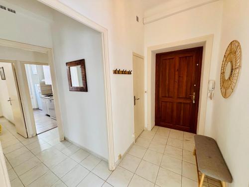 un couloir avec une porte en bois et du carrelage. dans l'établissement Magnifique appartement T4 Balcon Port Bandol, à Bandol