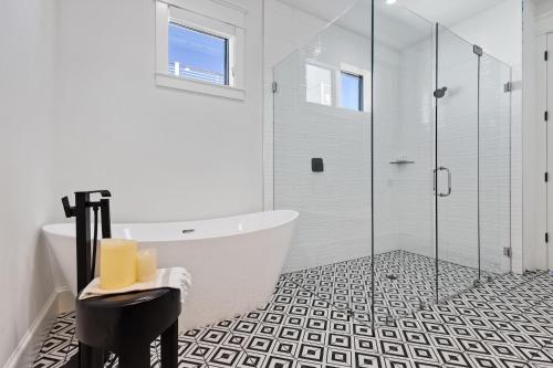 a bathroom with a tub and a glass shower at Big Nauti in Bradenton Beach