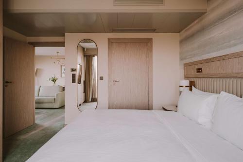 a bedroom with a large white bed and a chair at Hilton Swinoujscie Resort And Spa in Świnoujście