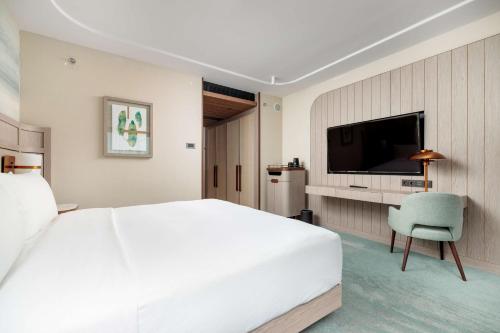 a bedroom with a large white bed and a tv at Hilton Swinoujscie Resort And Spa in Świnoujście