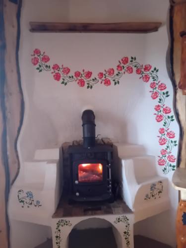 a stove in a room with a flowery wall at Casa rustica in Braşov