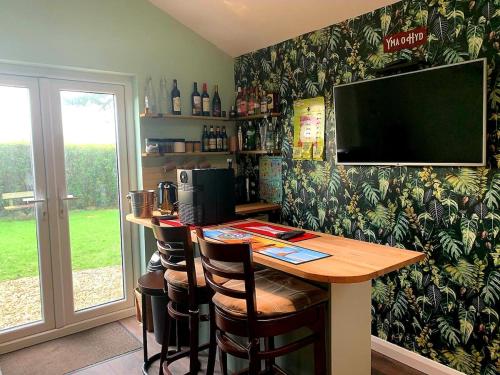 a kitchen with a bar with a television on the wall at Y Caban-The Cabin-2 Guests-Private Parking-Fast WIFI in Llanelli