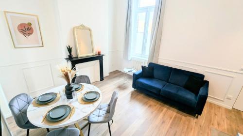 un salon avec une table et un canapé dans l'établissement L'haussmannien 1er Étage, à Abbeville