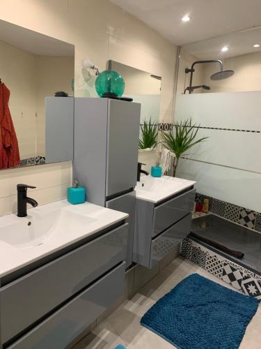 une salle de bain avec deux lavabos et un miroir dans l'établissement Maison climatisée 4 chambres terrasse 3 kms plage, à Saint-Laurent-de-la-Salanque