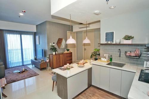a kitchen and living room with a sink and a counter at The Cendana La Riz Mansion Pakuwon Mall in Surabaya