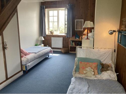 - une chambre avec deux lits et une chaise avec un ours en peluche dans l'établissement Nouveau - Le Bois d'Hautôt, à Hautot-sur-Mer