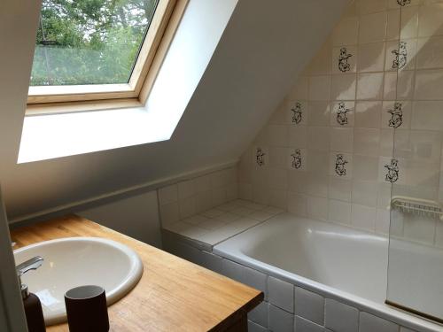 une salle de bain avec un lavabo et une baignoire dans l'établissement Nouveau - Le Bois d'Hautôt, à Hautot-sur-Mer