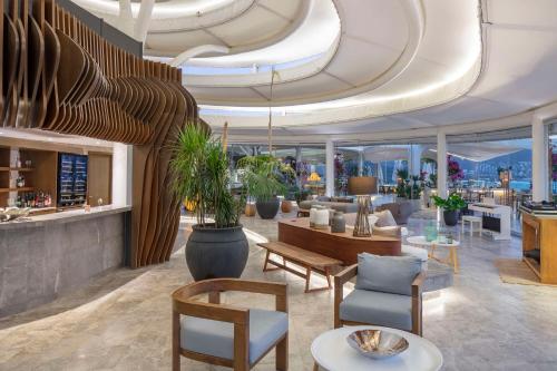 a lobby of a hotel with tables and chairs at Susona Bodrum, LXR Hotels & Resorts in Torba