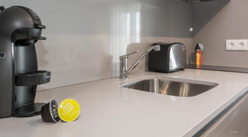 a kitchen counter with a sink and a coffee maker at Innapartments - São Gonçalinho in Aveiro