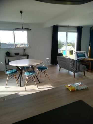 une salle à manger avec une table et des chaises dans une pièce dans l'établissement Meublé 3 étoiles Les Capucines, à Plouescat