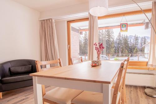 a dining room with a table and a window at Rehwiesa Studio C04 by Arosa Stay in Arosa