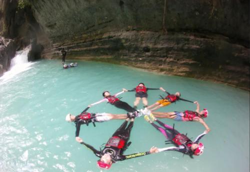 a group of people in a circle in the water at Moalboal Tropics in Moalboal