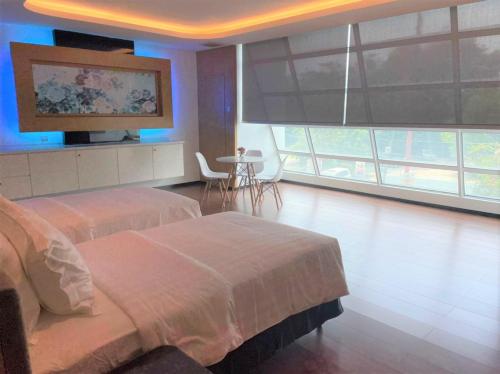 a bedroom with two beds and a flat screen tv at King's Lane Ipoh in Ipoh
