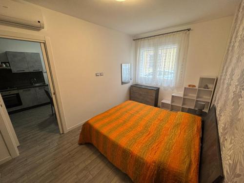 una camera da letto con un letto con una coperta arancione di Sun House a Quartu SantʼElena