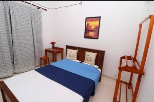 a bedroom with two beds and a chair in it at Pawra wood in in Bahirawakanda