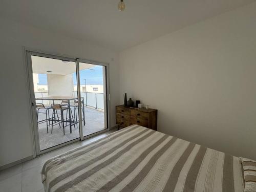 une chambre blanche avec un lit et un balcon dans l'établissement Appartement dans résidence avec piscine, à Calvi