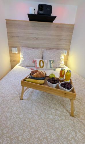 - un plateau de nourriture assis au-dessus d'un lit dans l'établissement Love nest 1er Étage, à Abbeville