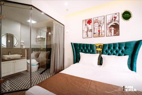 - une chambre avec un lit doté d'une tête de lit bleue et une salle de bains dans l'établissement Chuỗi villa 7 Ngủ Sun feria 888 - bể bơi - BBQ -gần Bãi BIỂN BÃI CHÁY, à Hạ Long