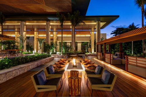 an outdoor patio with chairs and tables in a building at Conrad Tulum Riviera Maya in Tulum