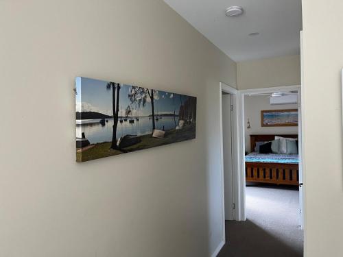 a painting hanging on a wall in a bedroom at Bagnalls beach house in Corlette