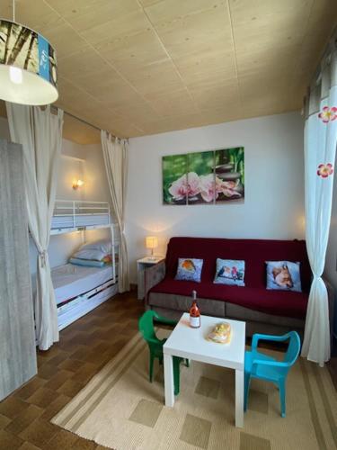 un salon avec un canapé, une table et un lit dans l'établissement Location Appartement LA TRANCHE SUR MER, à La Tranche-sur-Mer
