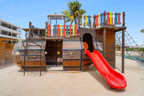 a playground with a red slide on a beach at Mangrove Beach Corendon Curacao All-Inclusive Resort, Curio by Hilton in Willemstad