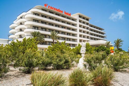 a hotel on the beach with plants in front of it at Mangrove Beach Corendon Curacao All-Inclusive Resort, Curio by Hilton in Willemstad