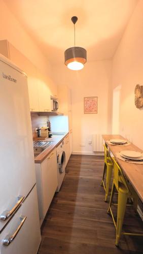 une cuisine avec un comptoir et une table avec des chaises jaunes dans l'établissement Le vintage RDC, à Abbeville