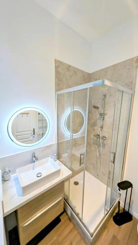 une salle de bain avec un lavabo et une douche dans l'établissement Le vintage RDC, à Abbeville