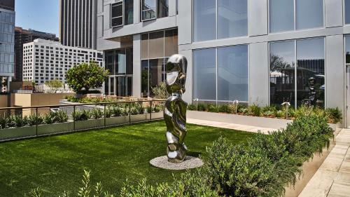 a sculpture of a woman on a lawn in front of a building at Conrad Los Angeles in Los Angeles