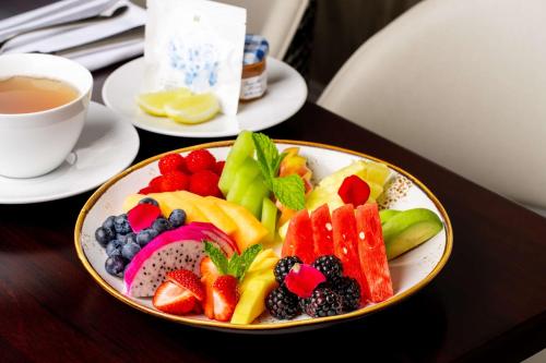 a plate of fruit on a table with a cup of tea at Signia by Hilton San Jose in San Jose
