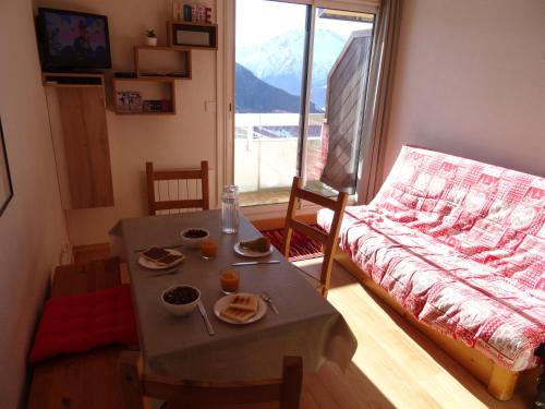 un salon avec une table et un canapé dans l'établissement Superbe Appartement T2 - Alpe d'Huez Quartier ECLOSE - vue imprenable exposé SUD, à L'Alpe-d'Huez