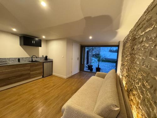 un salon avec un canapé et une cuisine dans l'établissement Balaruc Le Vieux Superbe studio dans maison médiévale avec terrasse et vue lagune de Thau, à Balaruc-le-Vieux