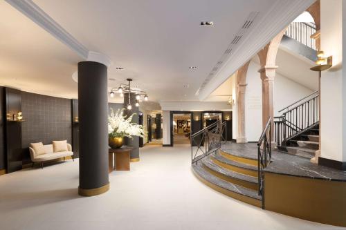 a lobby of a building with a spiral staircase at Hilton Heidelberg in Heidelberg