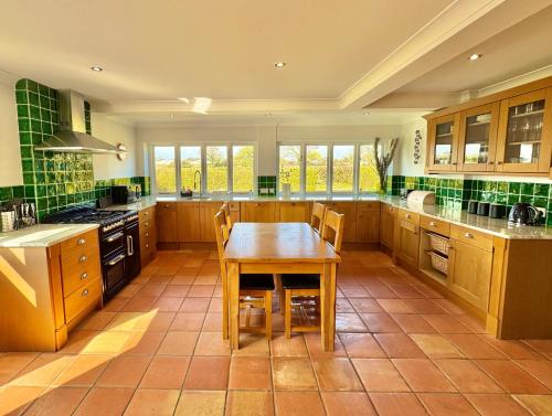 a large kitchen with a wooden table in it at Stunning 7 Bedroom Escape Near New Forest and Beach - Large Garden - Serene Setting - Sleeps 14 in Sway