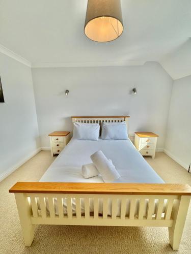 a bedroom with a large white bed with two night stands at Stunning 7 Bedroom Escape Near New Forest and Beach - Large Garden - Serene Setting - Sleeps 14 in Sway