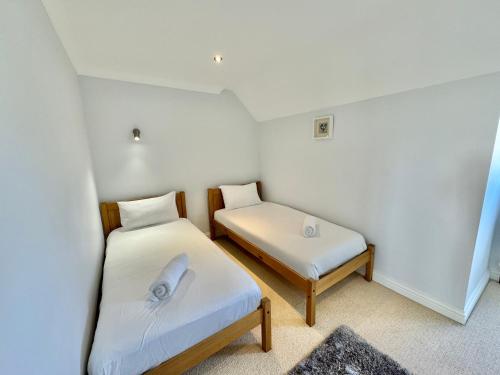 a small room with two beds in it at Stunning 7 Bedroom Escape Near New Forest and Beach - Large Garden - Serene Setting - Sleeps 14 in Sway