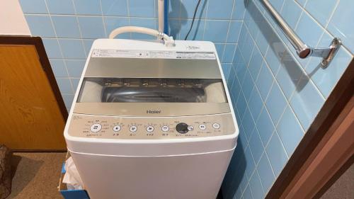 a washing machine in the corner of a kitchen at 瀬戸内塩上町 in Sambanchō