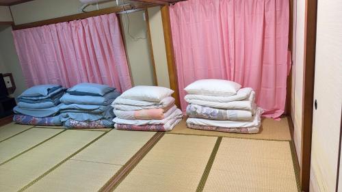 a room with a pile of blankets and pillows at 瀬戸内塩上町 in Sambanchō
