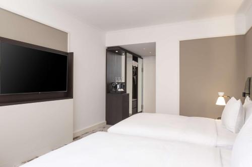 a hotel room with a bed and a flat screen tv at Hilton Heidelberg in Heidelberg