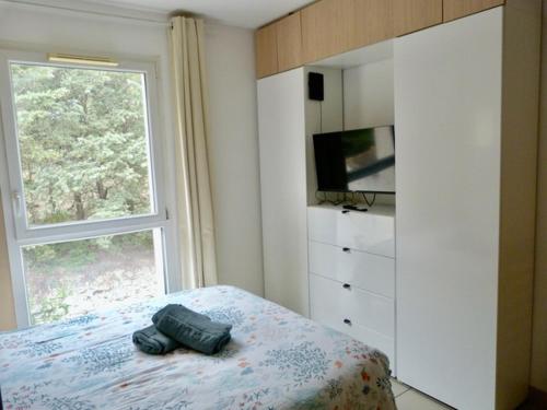 - une chambre avec un lit, une fenêtre et une commode dans l'établissement Le clos d'Aix studio 205 parking et piscine gratuite, à Aix-en-Provence